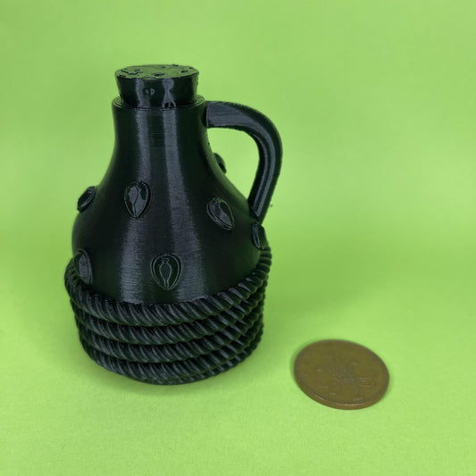 Alchemists Carafe in Black, on Green Background. 2 pence coin for scale